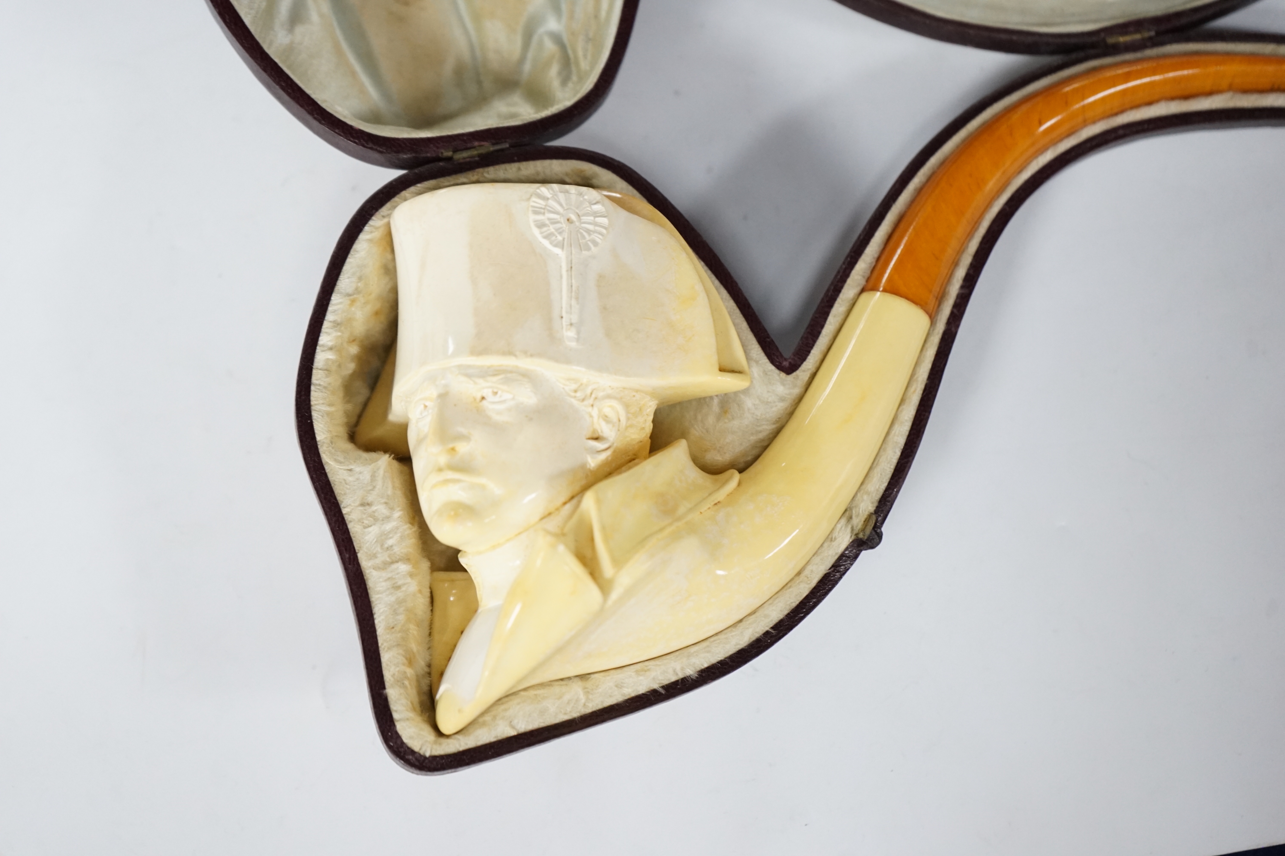 A large cased Meerschaum ‘Napoleon bust’ novelty pipe, early 20th century, with amber mouthpiece, 24cm long